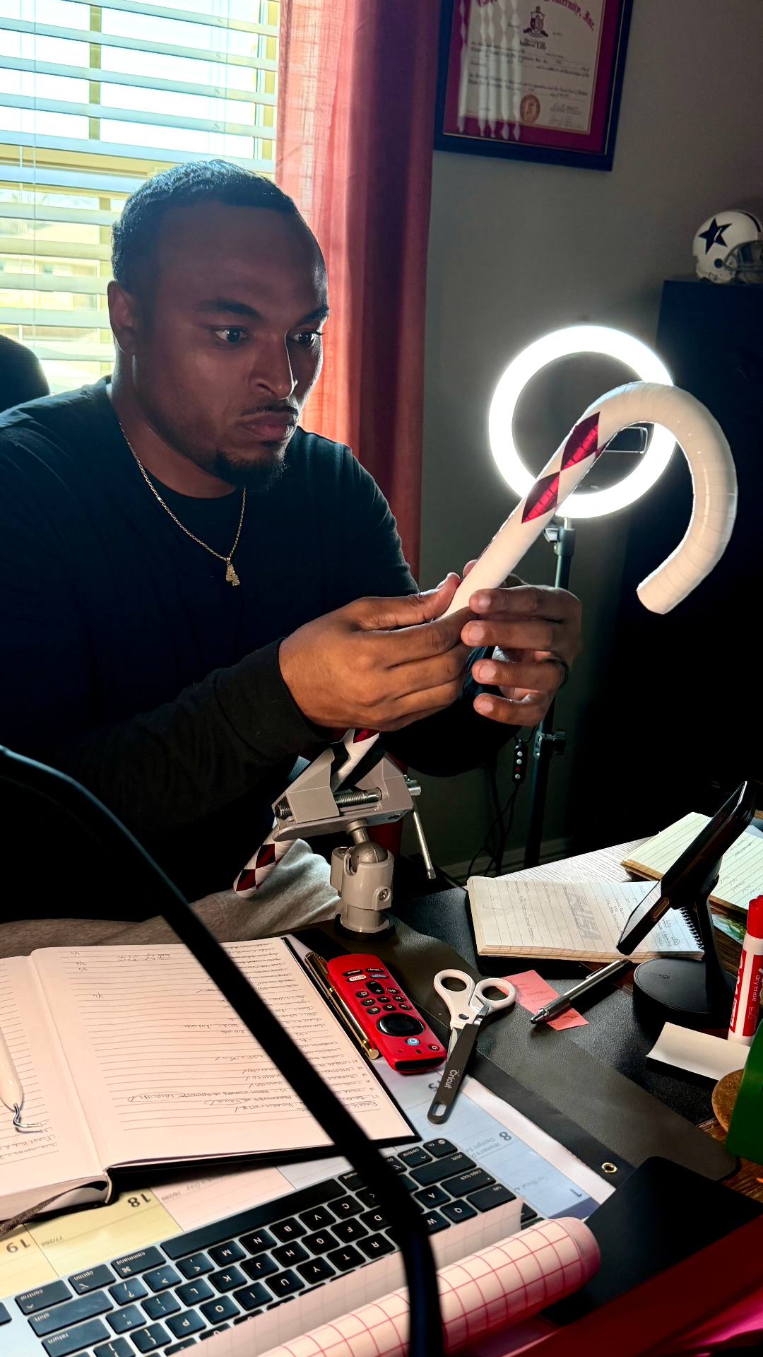 Wrapping a white and crimson cane under studio lighting