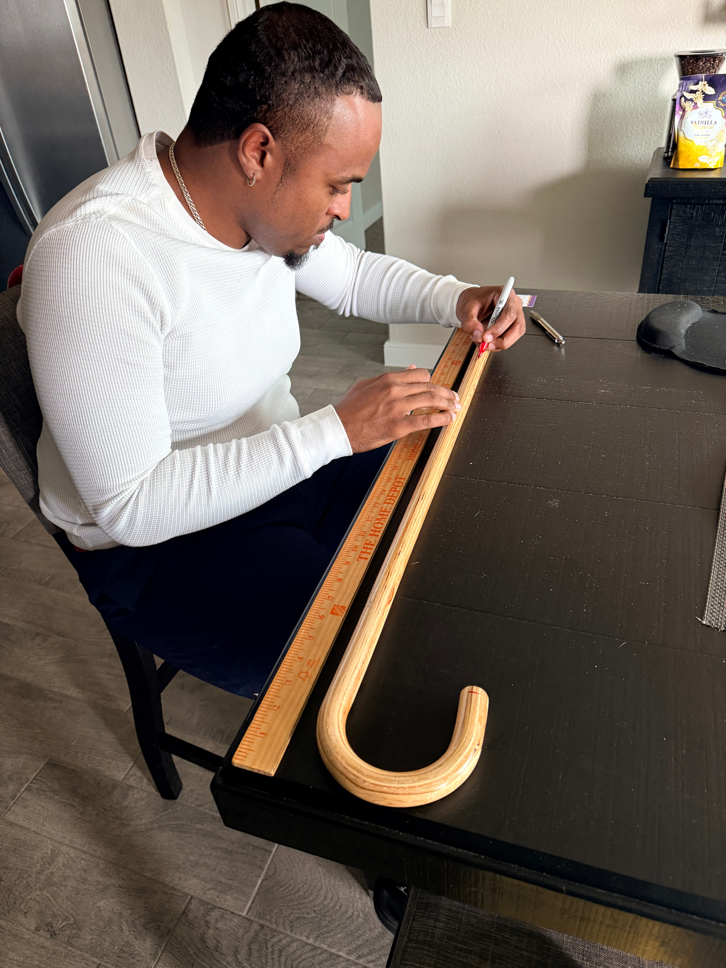 Craftsman measuring a wooden cane blank in the workshop